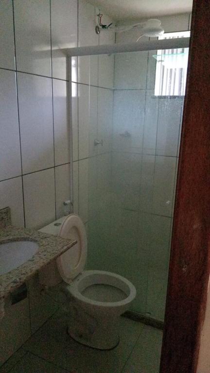 a bathroom with a toilet and a glass shower at Refúgio da Light in Carmo