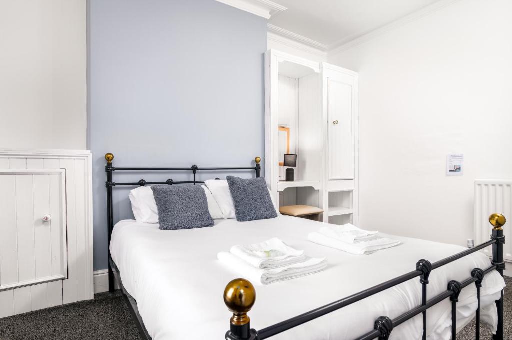 a white bedroom with a black and white bed at Blencathra Rooms, Whitby in Whitby