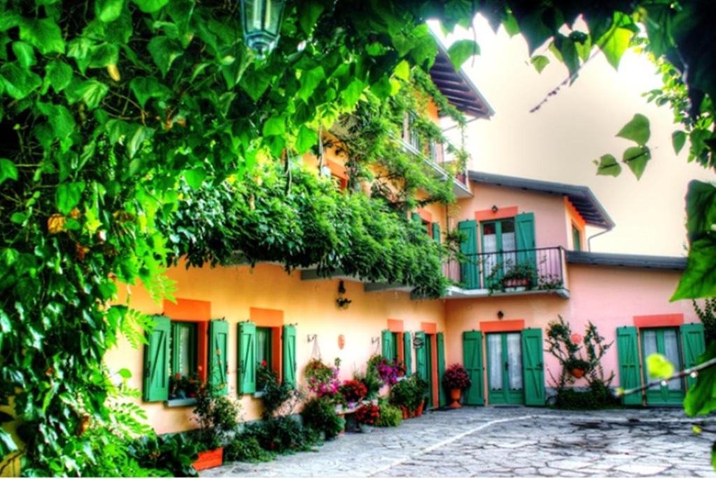 budynek z zielonymi i różowymi drzwiami i kwiatami w obiekcie Casa Violetta B&B w mieście Agrate Conturbia