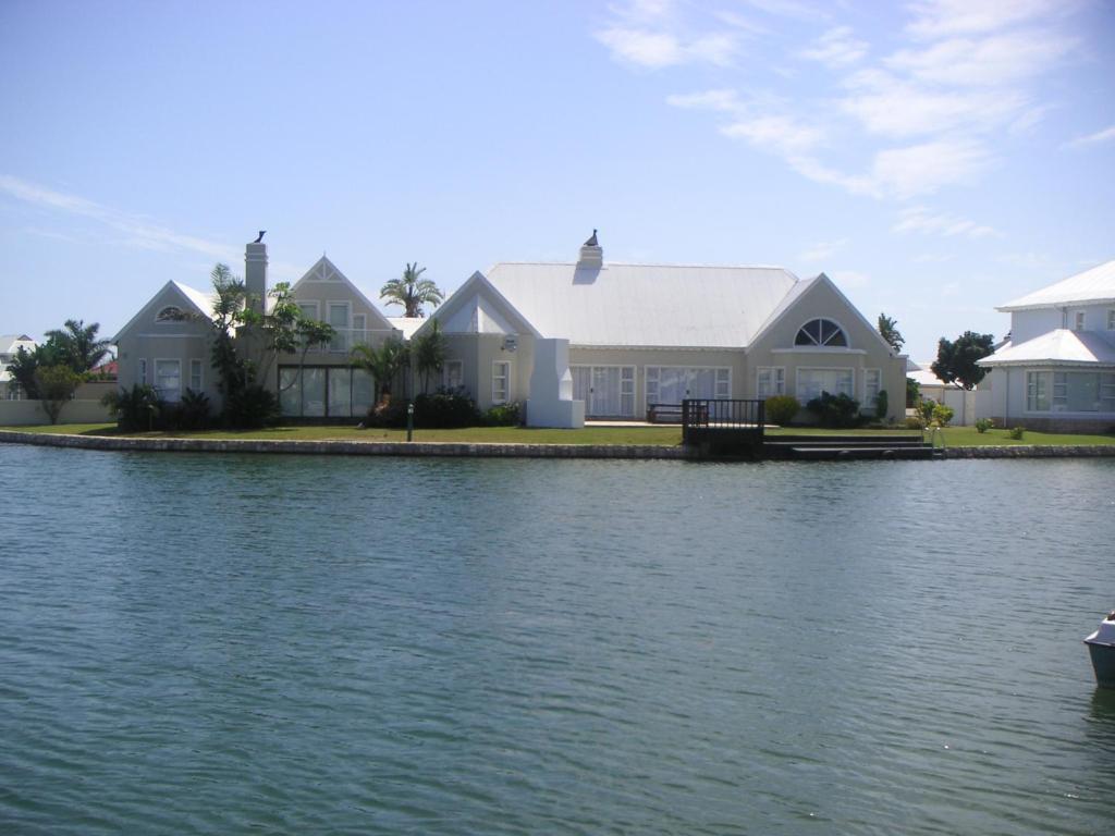 a house on the shore of a body of water at Waterside Living MM1297 in Jeffreys Bay