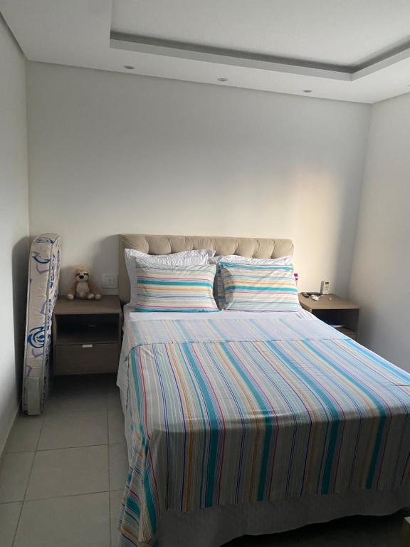 a bedroom with a bed with a striped comforter at Apartamento exclusivo COP 30 in Belém