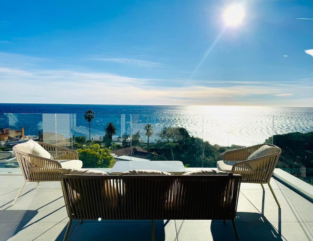 un patio avec une table et des chaises et l'océan dans l'établissement Appartement vue mer, piscine, 150m de la plage, Les Issambres, aux Issambres