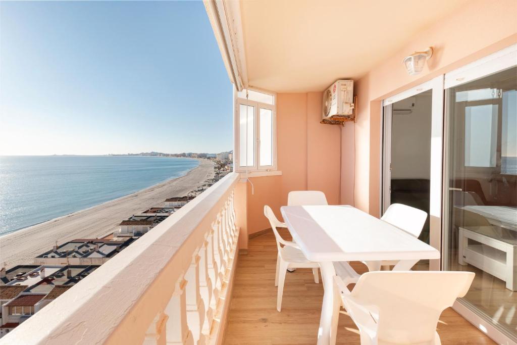 a balcony with a table and chairs and the ocean at Apartamentos Turisticos Isla Grosa in La Manga del Mar Menor