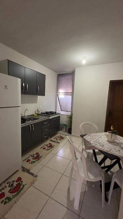 a kitchen with a table and a white refrigerator at Residencial Maldonado Eckert - APTO 199 E - Praia Grande in São Francisco do Sul