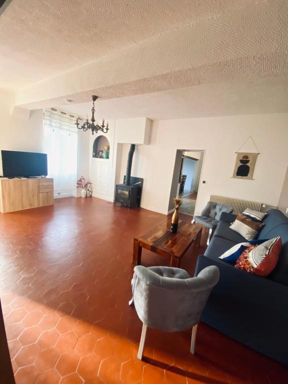 un salon avec un canapé bleu et une table dans l'établissement Appartement Indépendant avec jardin, entrée autonome par boîte à clé , Self-Check-In, à Saint-Clément