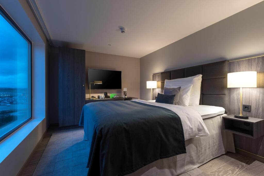 a hotel room with a bed and a large window at Clarion Hotel Air in Sola