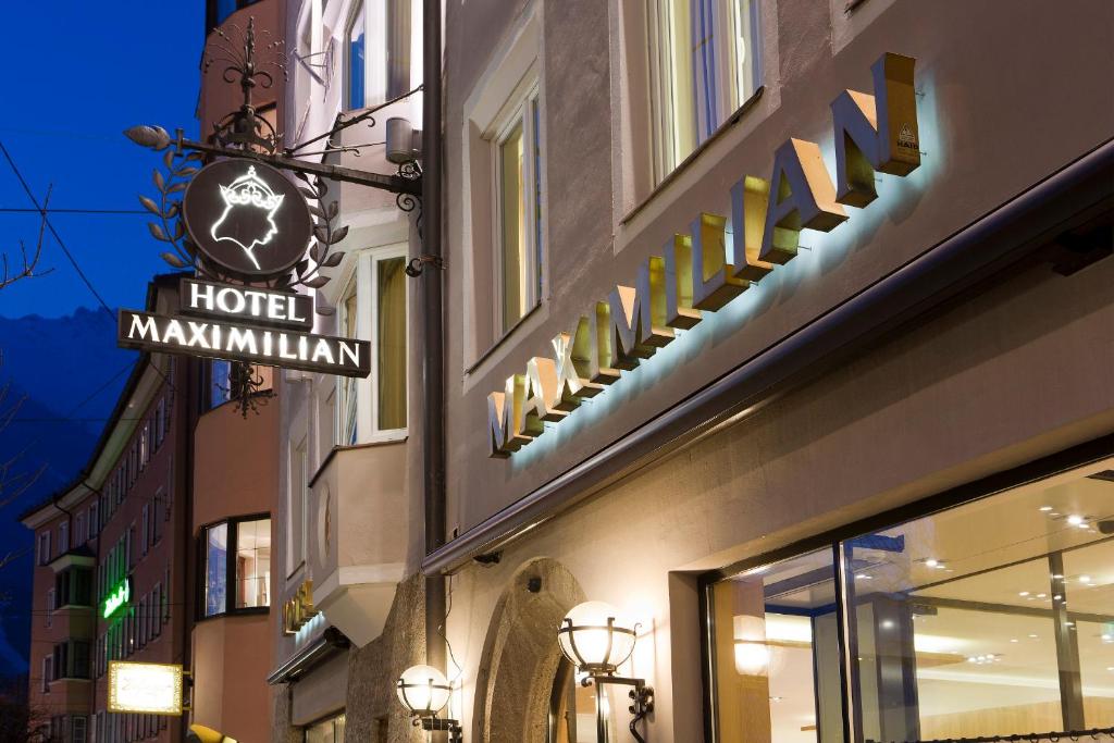 a hotel maximillian sign on the side of a building at Hotel Maximilian - Stadthaus Penz in Innsbruck