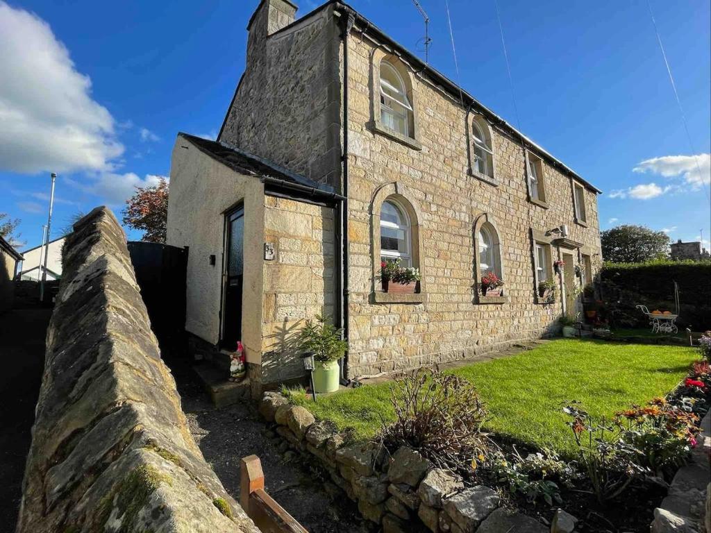 una vecchia casa in pietra con un muro di pietra di Cottage Apartment Near Lancaster University a Galgate