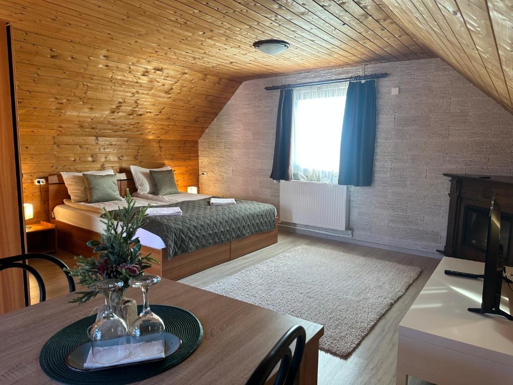 a living room with a bed and a table with a table sidx sidx at Somogyi Vendégház in Bancu
