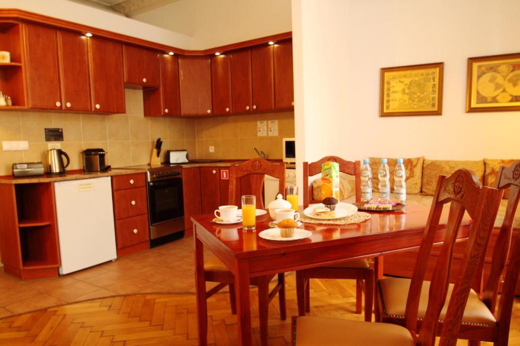 a kitchen with a wooden table and a dining room at Ventus Rosa Apartments in Krakow