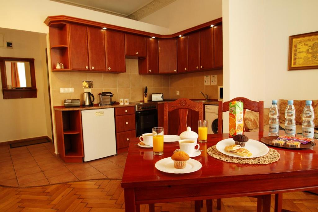 a kitchen with a wooden table with food on it at Ventus Rosa Apartments in Krakow
