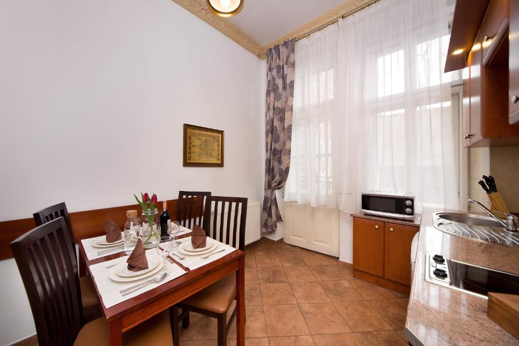 a dining room with a table and a kitchen at Ventus Rosa Apartments in Krakow