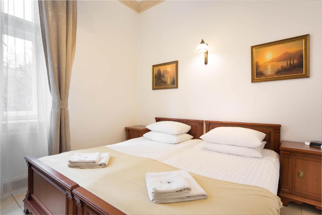 a bedroom with two beds with towels on them at Ventus Rosa Apartments in Krakow