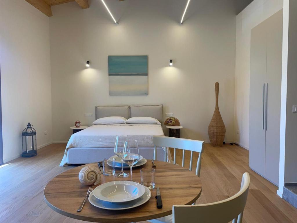 a bedroom with a bed and a wooden table with plates on it at Casa faro in Realmonte