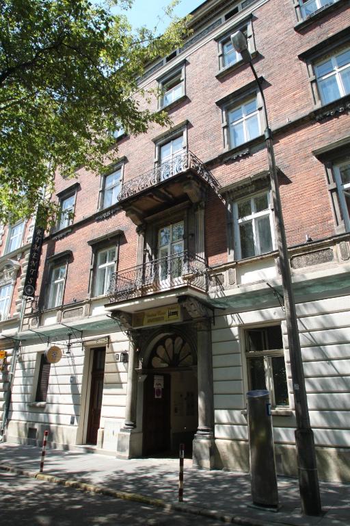 a large brick building with a door and balcony at Ventus Rosa Apartments in Krakow
