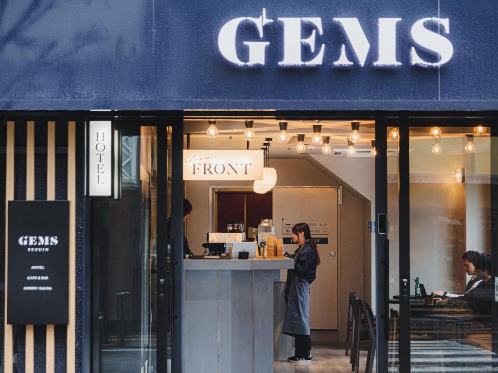 a man standing outside of a front of a store at GEMS YUFUIN Hotel and Spa Cafe Bar in Yufu