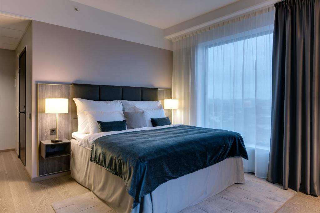 a bedroom with a large bed and a large window at Clarion Hotel Air in Sola