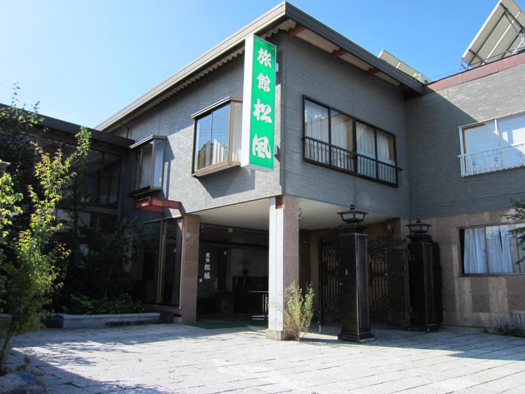 a building with a sign on the side of it at Ryokan Matsukaze in Matsumoto