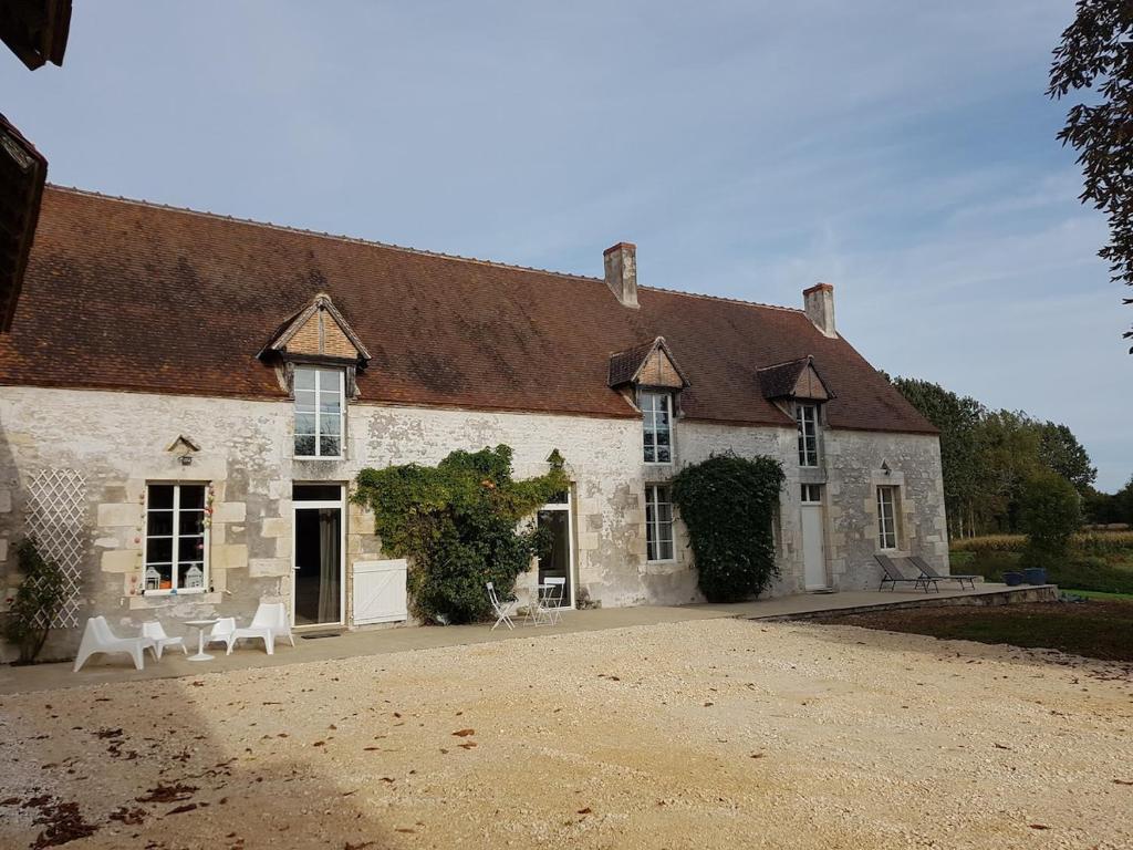 - un grand bâtiment avec deux chaises blanches devant dans l'établissement Grande maison de familles à Sancerre, à Feux