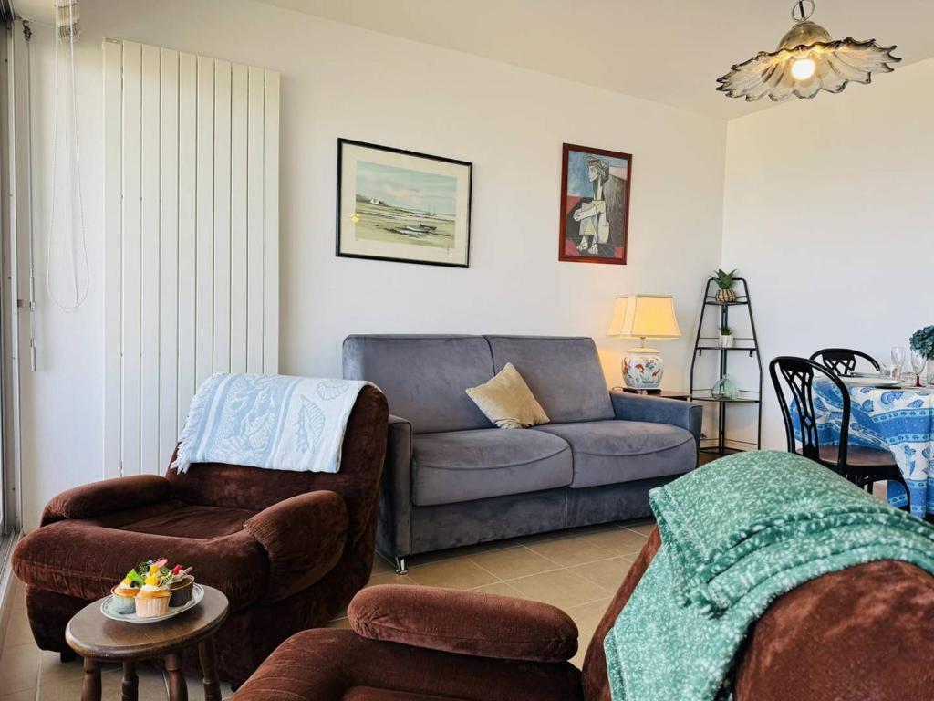 un salon avec un canapé et une chaise dans l'établissement Spacieux 2 pièces vue mer, parking, wifi, à Quiberon