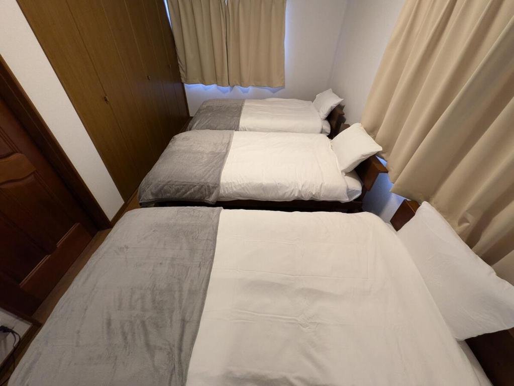Postel nebo postele na pokoji v ubytování Villa Tojinbo ヴィラ東尋坊 1棟貸切10人 東尋坊5分 芝政15分 恐竜博物館55分 かに