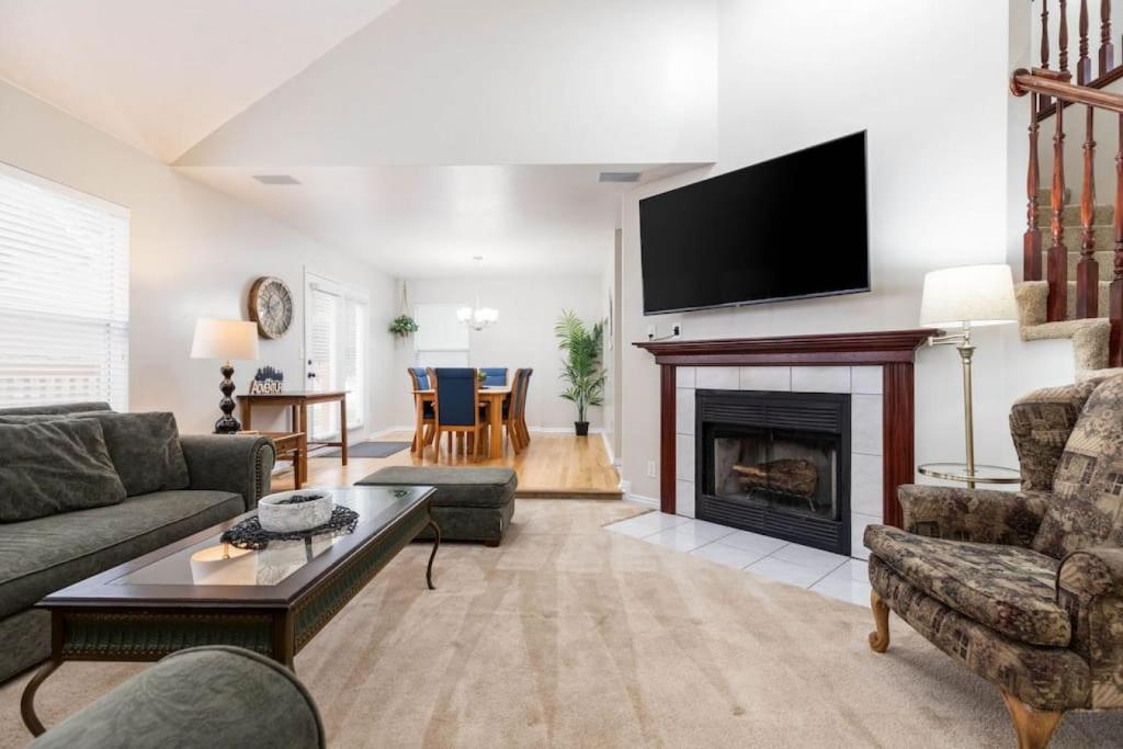 Una sala de estar con chimenea y TV de pantalla plana. en Clover Spring Wasatch Refuge, en Cottonwood Heights