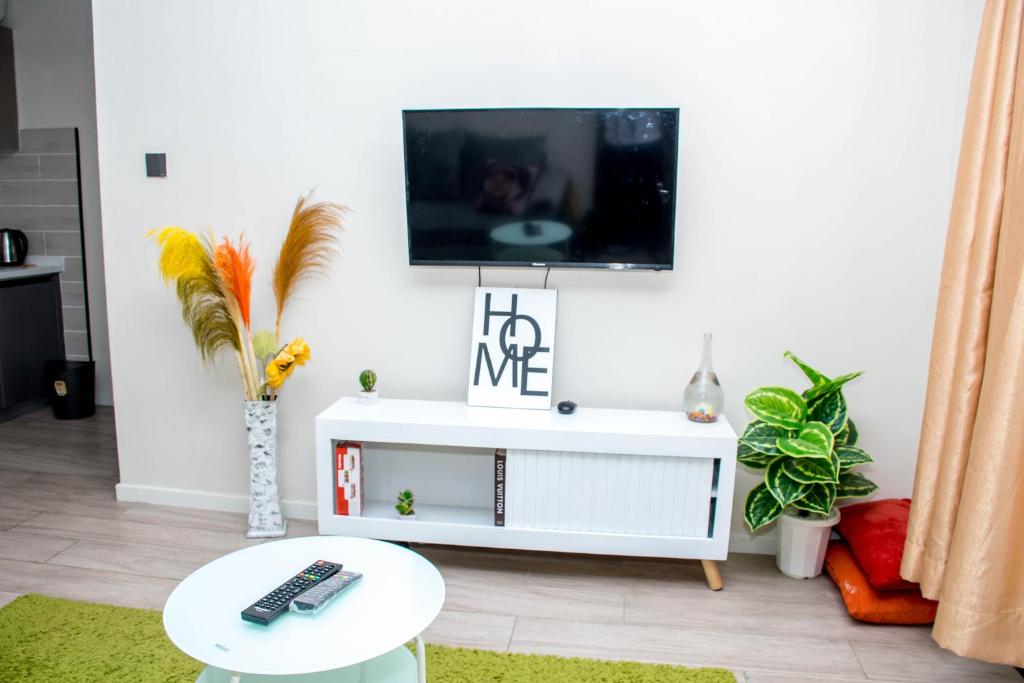 a living room with a tv and a white cabinet at Aries Residence Sabaki in Nairobi