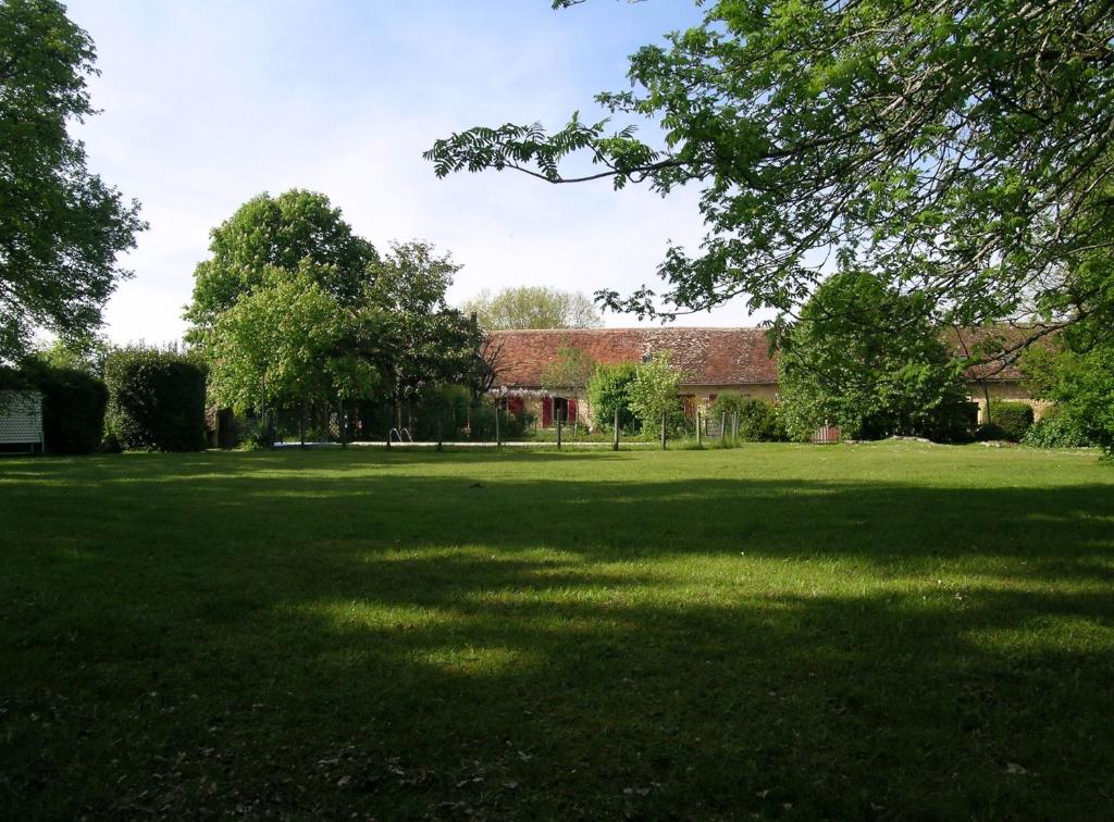 Eine große Rasenfläche mit einem Gebäude im Hintergrund in der Unterkunft Domaine de Bellevue Cottage en Périgord- Bergerac 5mn - Petits-déjeuners inclus - Salle d'eau privative - Parc 3ha - Parking Privé Gratuit in Lembras