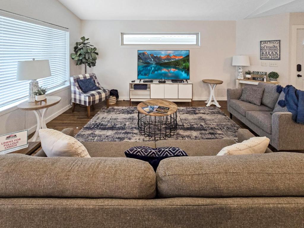 ein Wohnzimmer mit zwei Sofas und einem Fernseher in der Unterkunft The Barefoot Lodge at Bridges Bay Resort in Arnolds Park