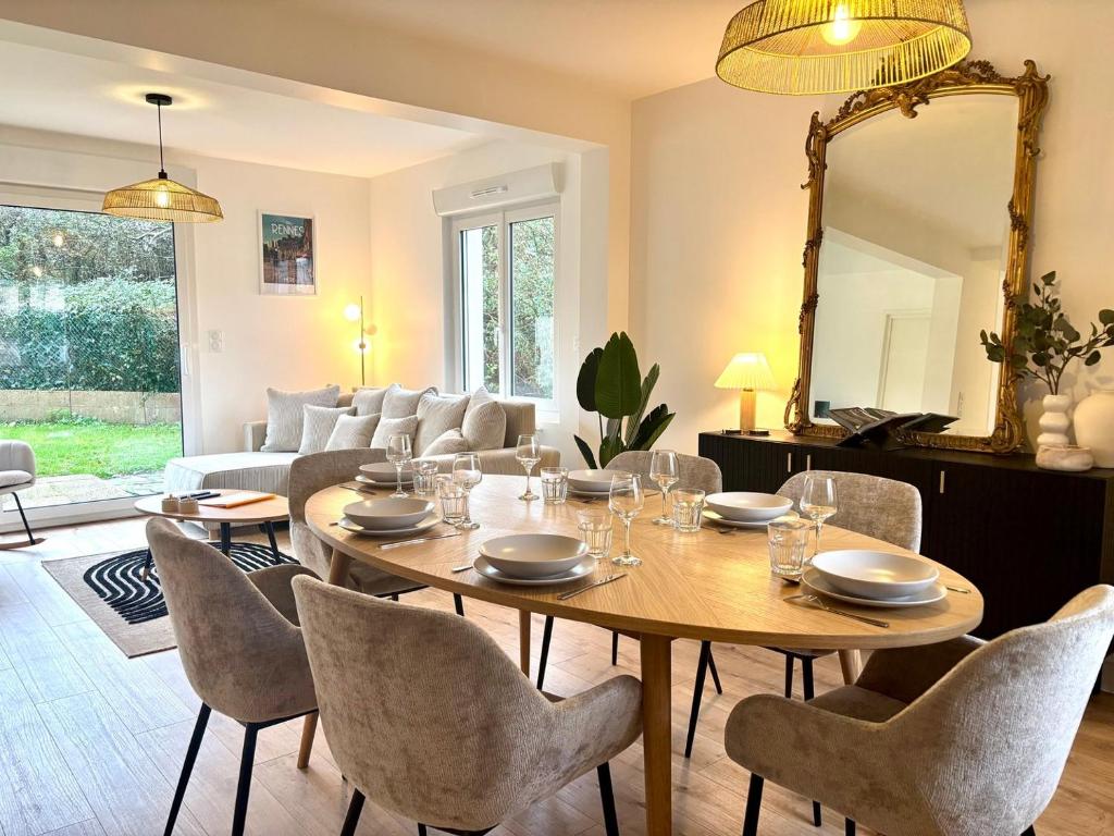 - un salon avec une table, des chaises et un miroir dans l'établissement Le Jouon - Magnifique Maison de Ville avec Jardin, à Rennes