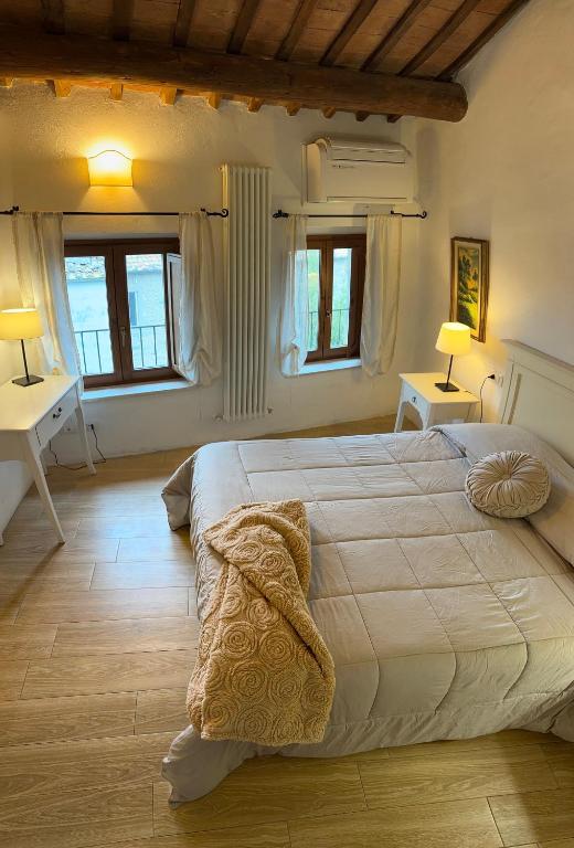 Un dormitorio con una cama grande y dos ventanas. en Casa Bordoli, en Cortona