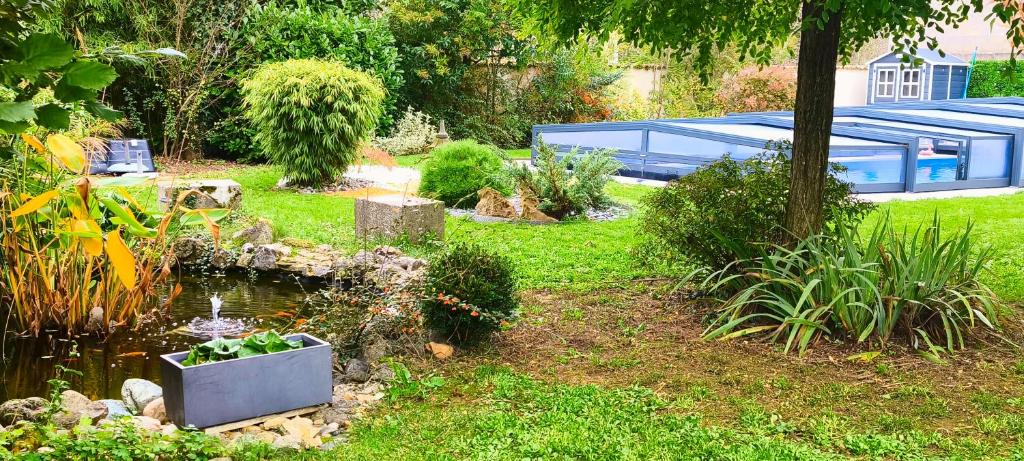 a garden with a pond in the middle of a yard at House 10 people, heated pool, countryside in Marthon