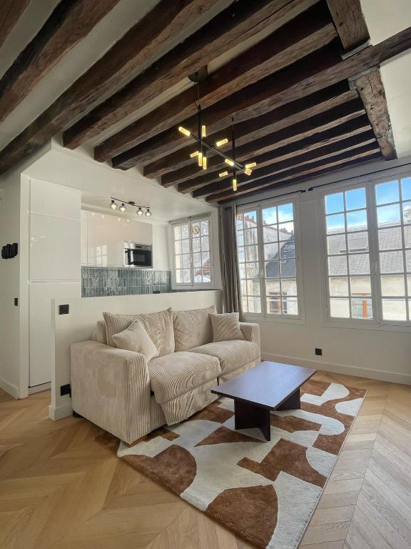 un salon avec un canapé et une table dans l'établissement Renovated Studio Centre Paris-24m, à Paris