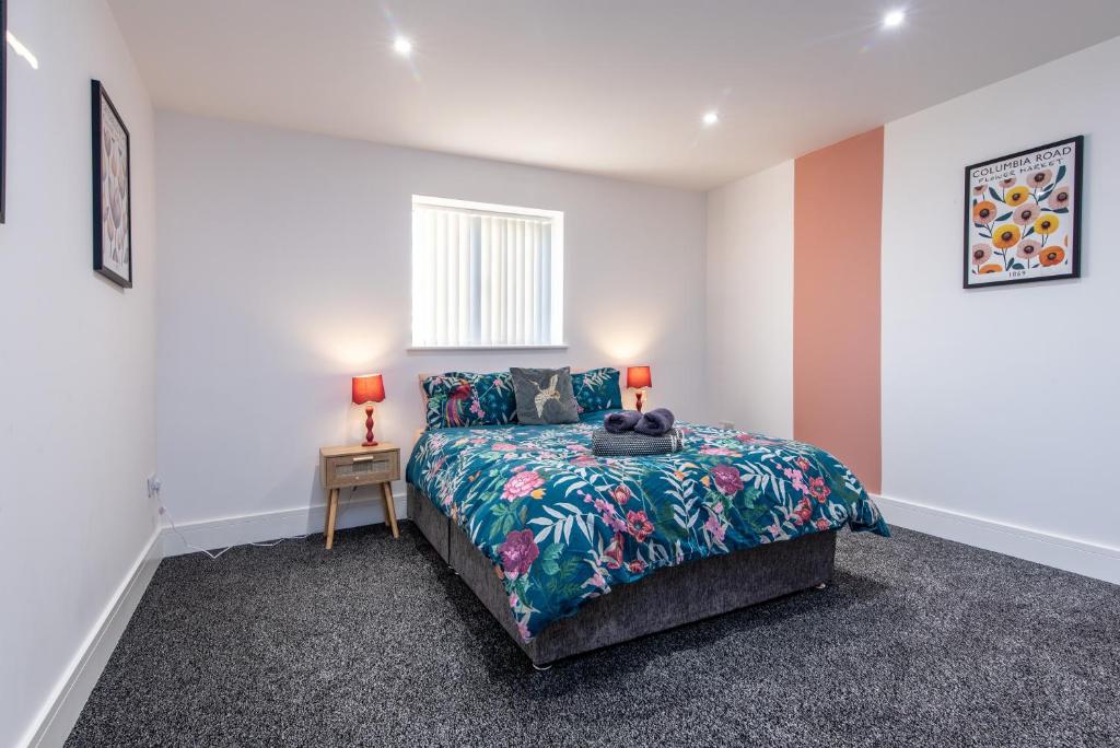 ein Schlafzimmer mit einem Bett und einem Tisch mit zwei Lampen in der Unterkunft Chapel Street Apartments - Great Transport & Local Amenities in Long Eaton