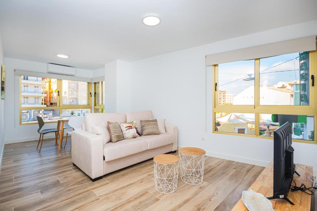 a living room with a couch and a tv at Vila Playa - Villajoyosa in Villajoyosa