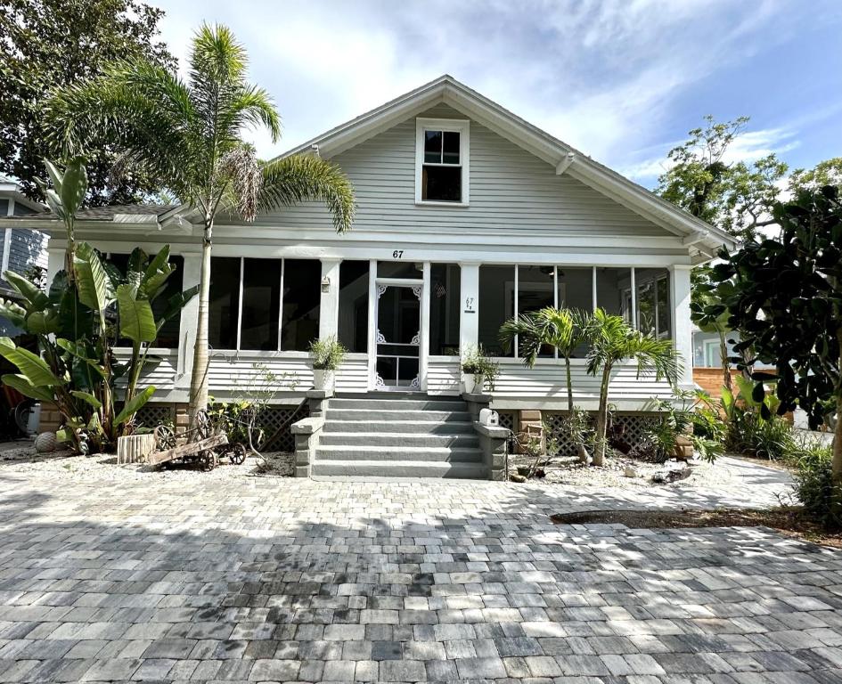 a white house with a palm tree in front of it at Lemon Street Retreat Renovated 1920 Craftman ,Half mile Stroll to Historic DT ,Beaches 3 mi to Vilano & 5 to St Aug in Saint Augustine