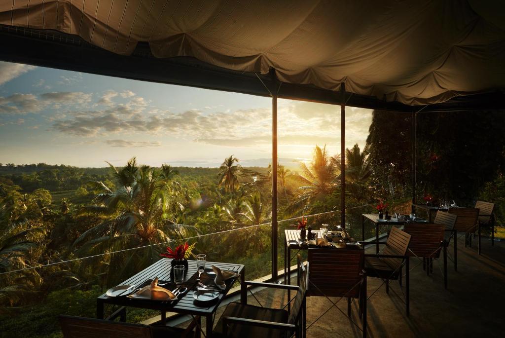 a restaurant with tables and chairs with a view at Kahanda Kanda in Koggala