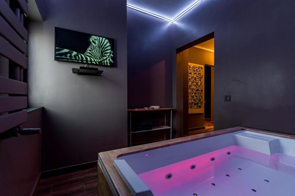 a large tub in a room with a tv on the wall at Downtown Calea Victoriei 100 Jacuzzi&Sauna&Bathtub in Bucharest