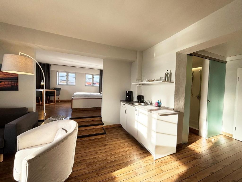 een woonkamer met een bank en een tafel en een keuken bij Pier 11 im Pierspeicher in Kappeln
