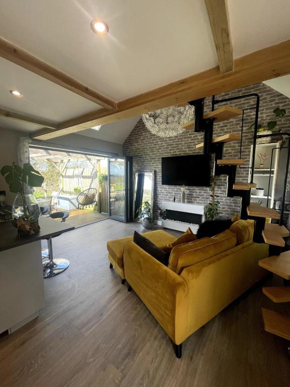 a living room with a yellow couch and a fireplace at Sunset Cottage in Warwick