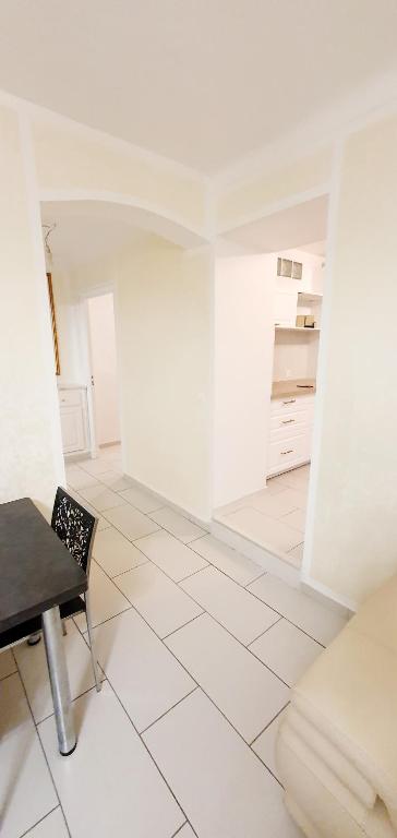 une pièce blanche avec une table et une chaise dans l'établissement Appartement 3 pièces sur Nice Centre, à Nice