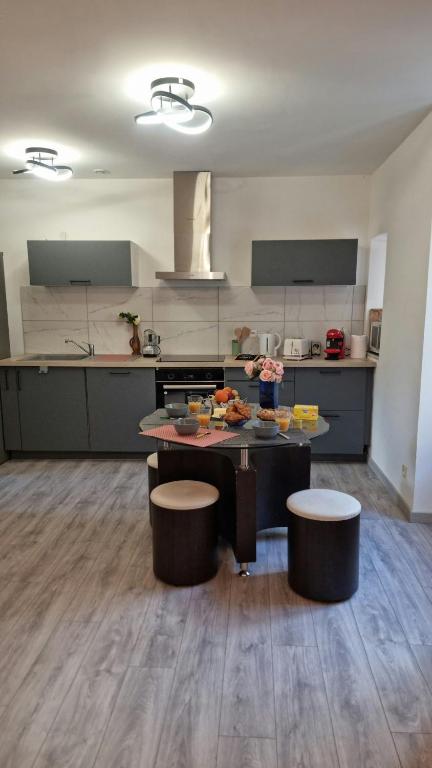 une cuisine avec une table et deux tabourets dans l'établissement T3 au Centre de Gourdon, à Gourdon