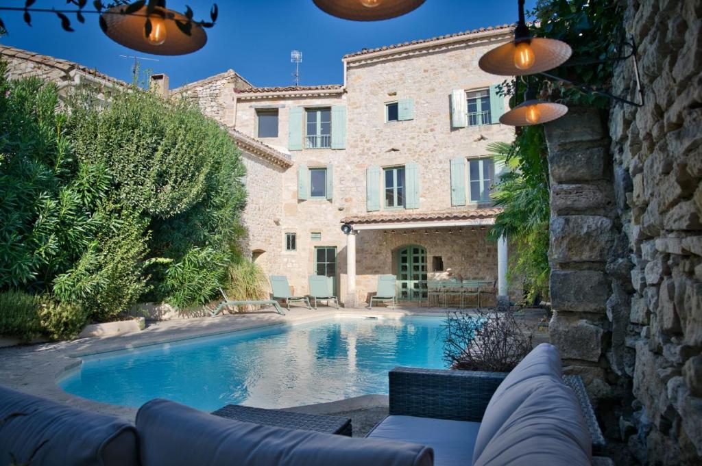 une piscine devant un immeuble dans l'établissement Mas piscine exposition sud Proche Uzès, à Collorgues