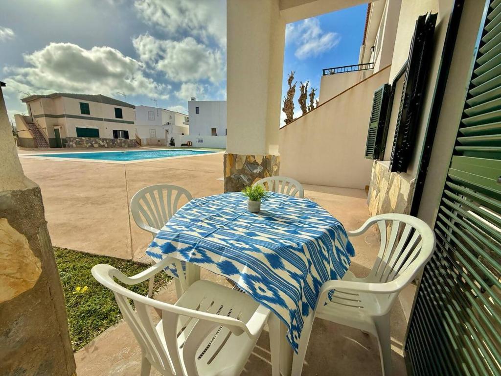 a table and chairs sitting on a porch with a table and chairs at Apartamento con piscina - Posta de sol in Cala en Forcat