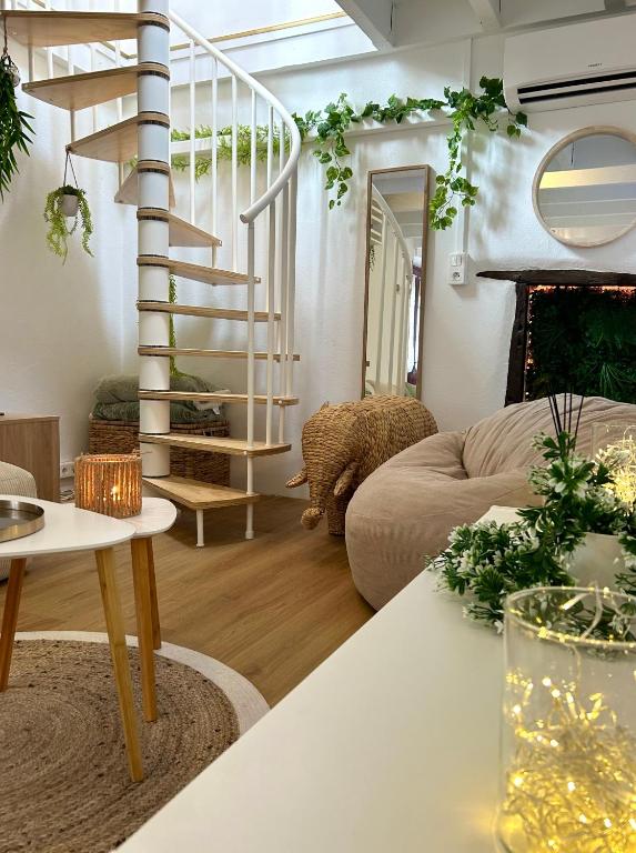 - un salon avec un escalier en colimaçon et un canapé dans l'établissement L 'Écrin - Balnéo & Cinéroom, à Poitiers