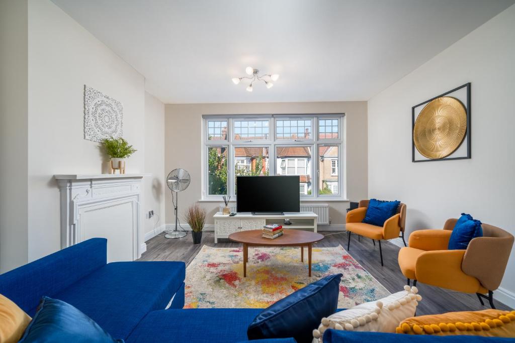 a living room with blue couches and a tv at Spacious Boutique 2 Bed Apartment Retreat Flexi BM in Finchley