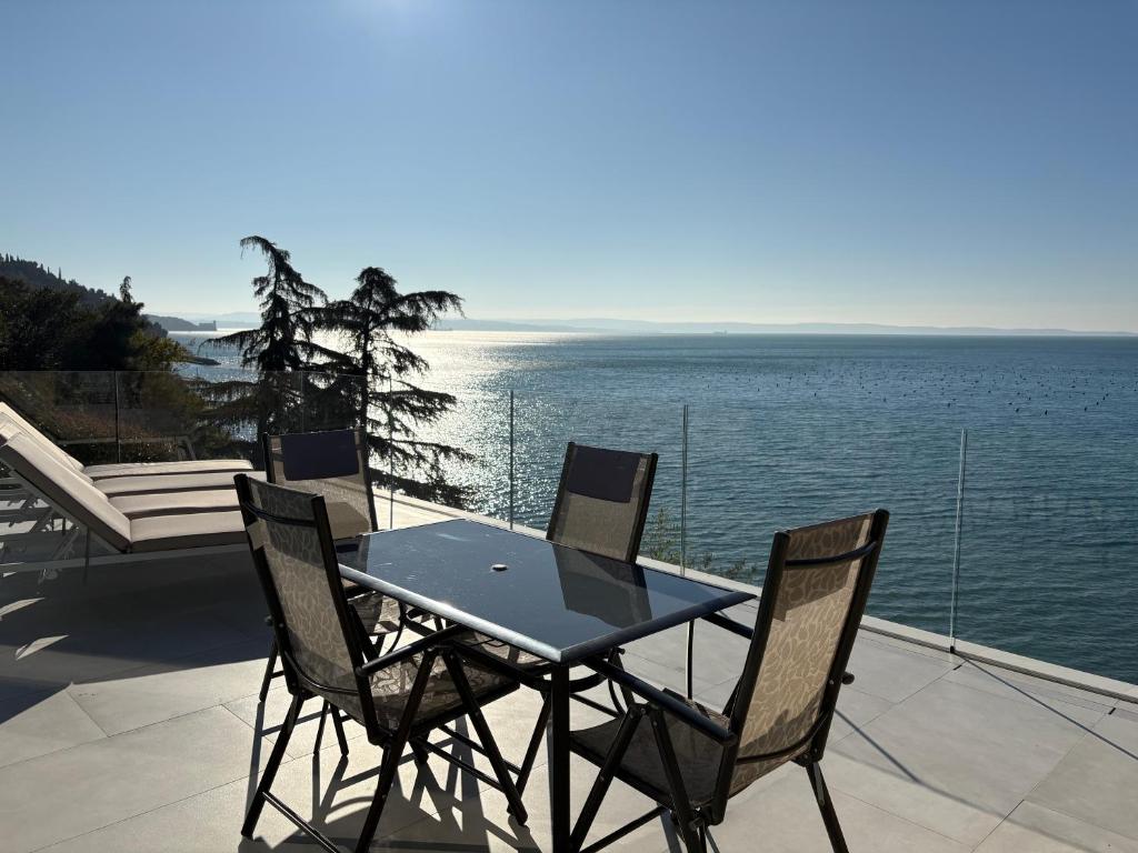 a table and chairs on a patio with the ocean at Seaside Resort in Trieste