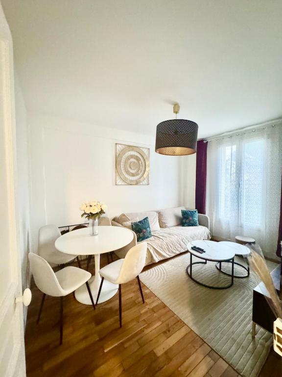 un salon avec un canapé, une table et des chaises dans l'établissement Très bel appartement proche Disney Paris, à Les Pavillons-sous-Bois