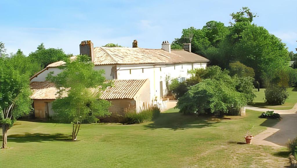 a large white house with a yard and trees at Maison de charme avec piscine et jardin à Saint-Vincent-la-Châtre in Saint-Vincent-la-Châtre
