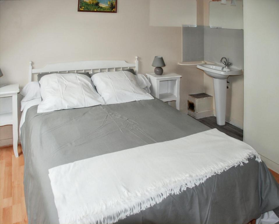 - une chambre avec un lit blanc et un lavabo dans l'établissement Maison charmante Jugon-les-Lacs, à Jugon Les Lacs